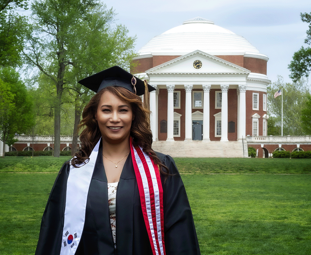 SCPS student smiling at graduation in front of UVA Rotunda