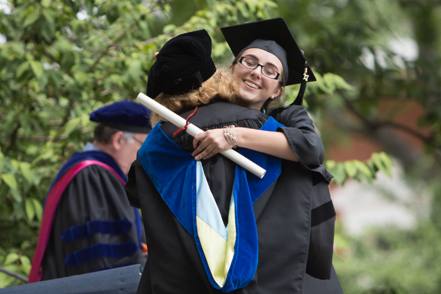 Two UVA graduates hug in celebration