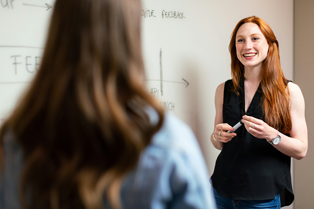 Woman smiling talking to another woman