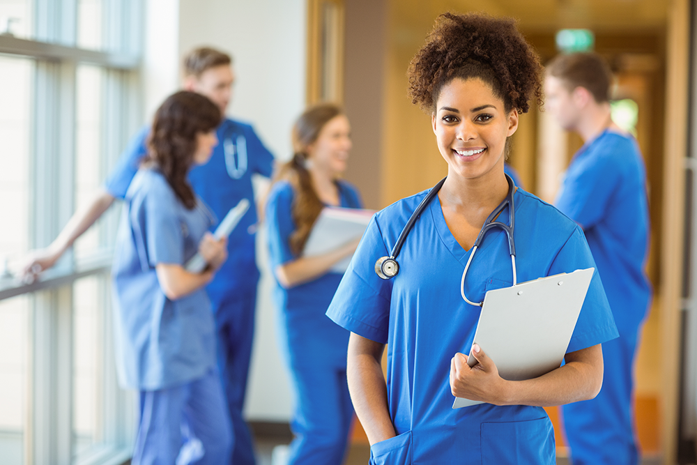 Female medical student standing in front of others smiling