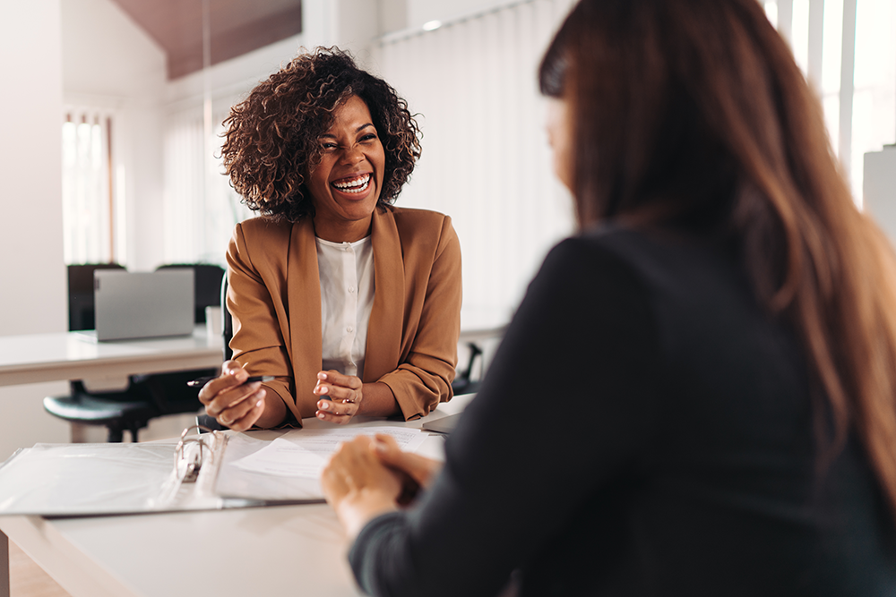 Female consultant smiling at client across desk