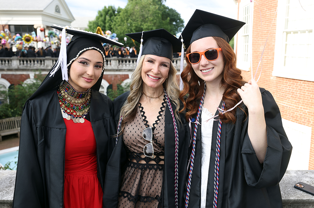 three UVA BIS female grads smile at the Rotunda