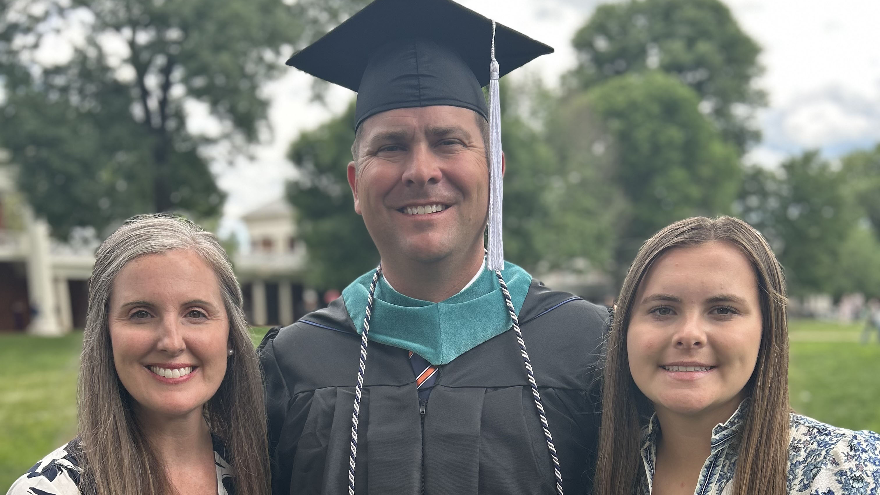 Captain Ryan Hutchison (center) poses at UVA final exercises with his wife (left) and daughter (right).