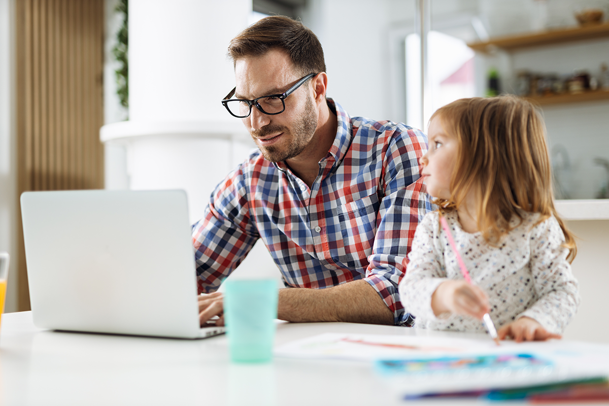 Man learning online with daughter at counter
