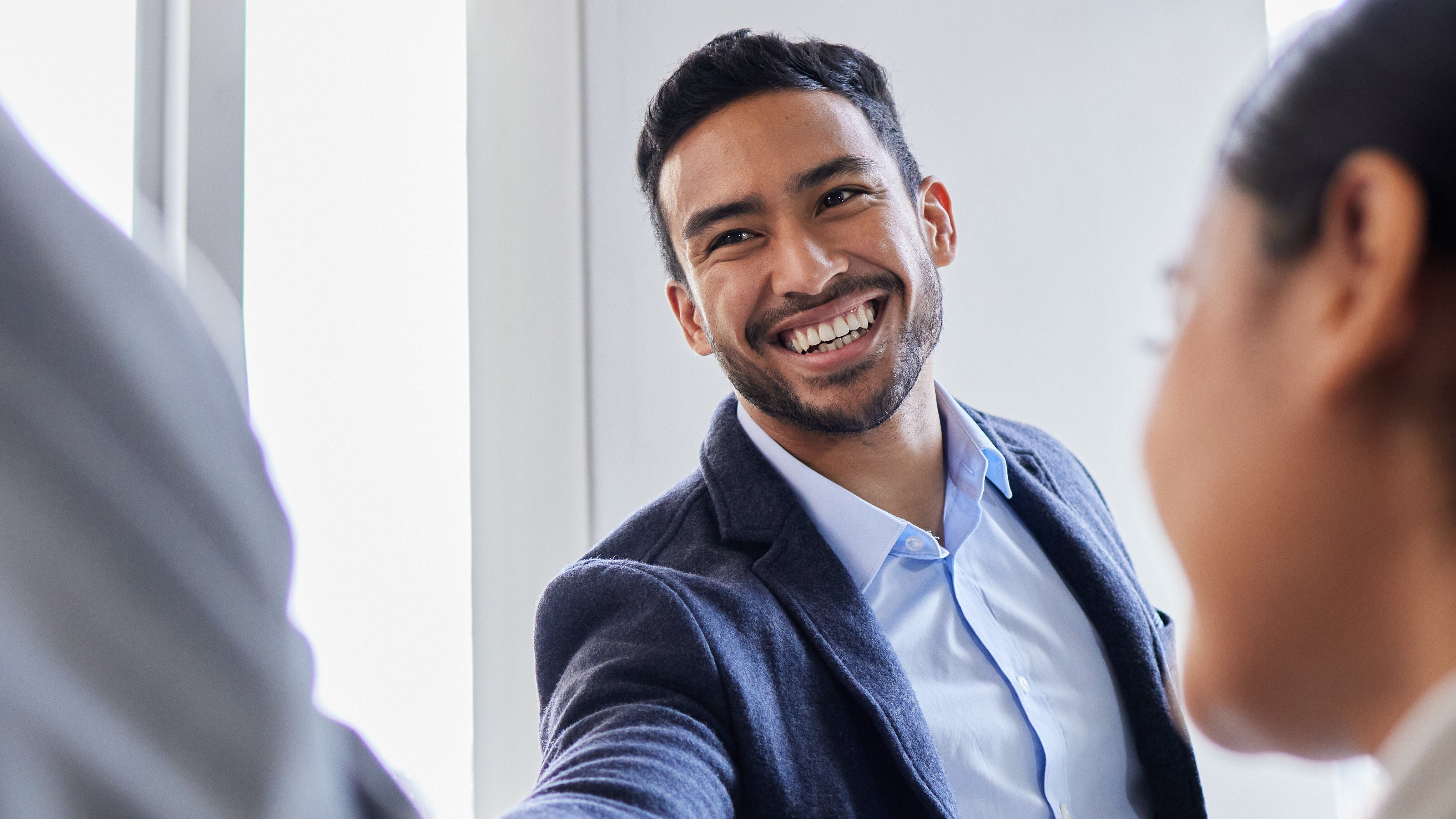 A coach shakes hands with someone in a classroom.