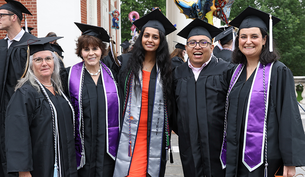 five SCPS students smile in front of UVA Rotunda at graduation