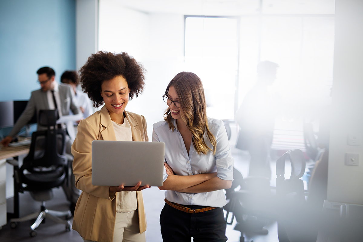 Two female colleagues look at a computer